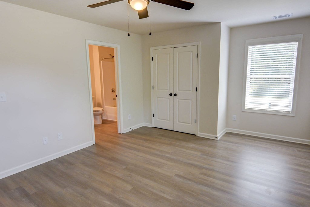 a bedroom with hardwood floors and a ceiling fan