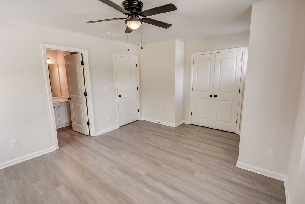 an empty living room with a ceiling fan