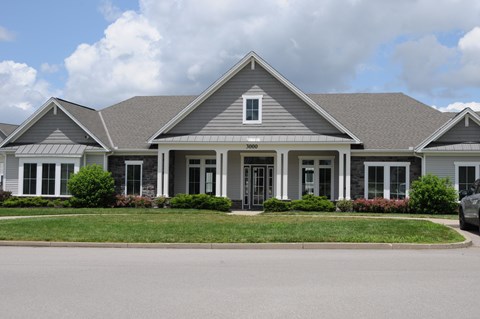 A house with a grey roof and a white car parked in front.