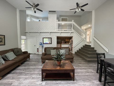 A living room with a brown couch and a wooden coffee table.