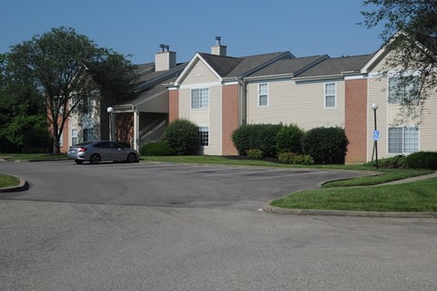 A car is parked in front of a building with a brick facade.