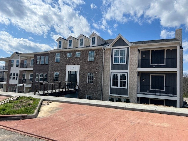 a large apartment building with a red brick sidewalk