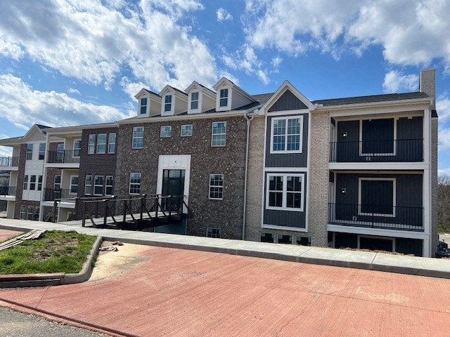 a large apartment building with a red brick sidewalk