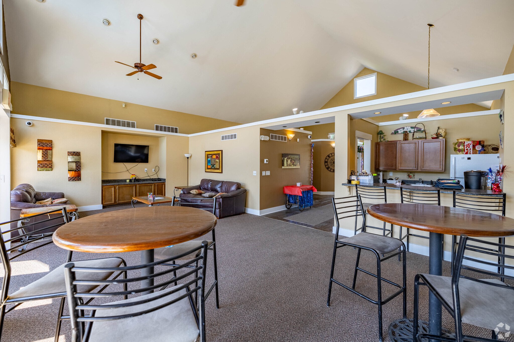 A living room with a brown table surrounded by chairs.