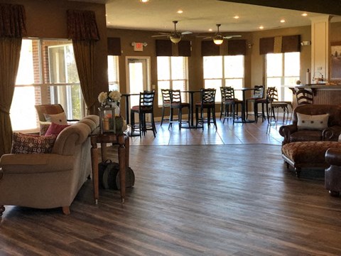 A living room with a couch, chairs, and a dining table at The Legends at Steeplechase Apartments, Richwood