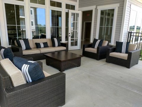 A patio with a couch, chairs, and a coffee table.