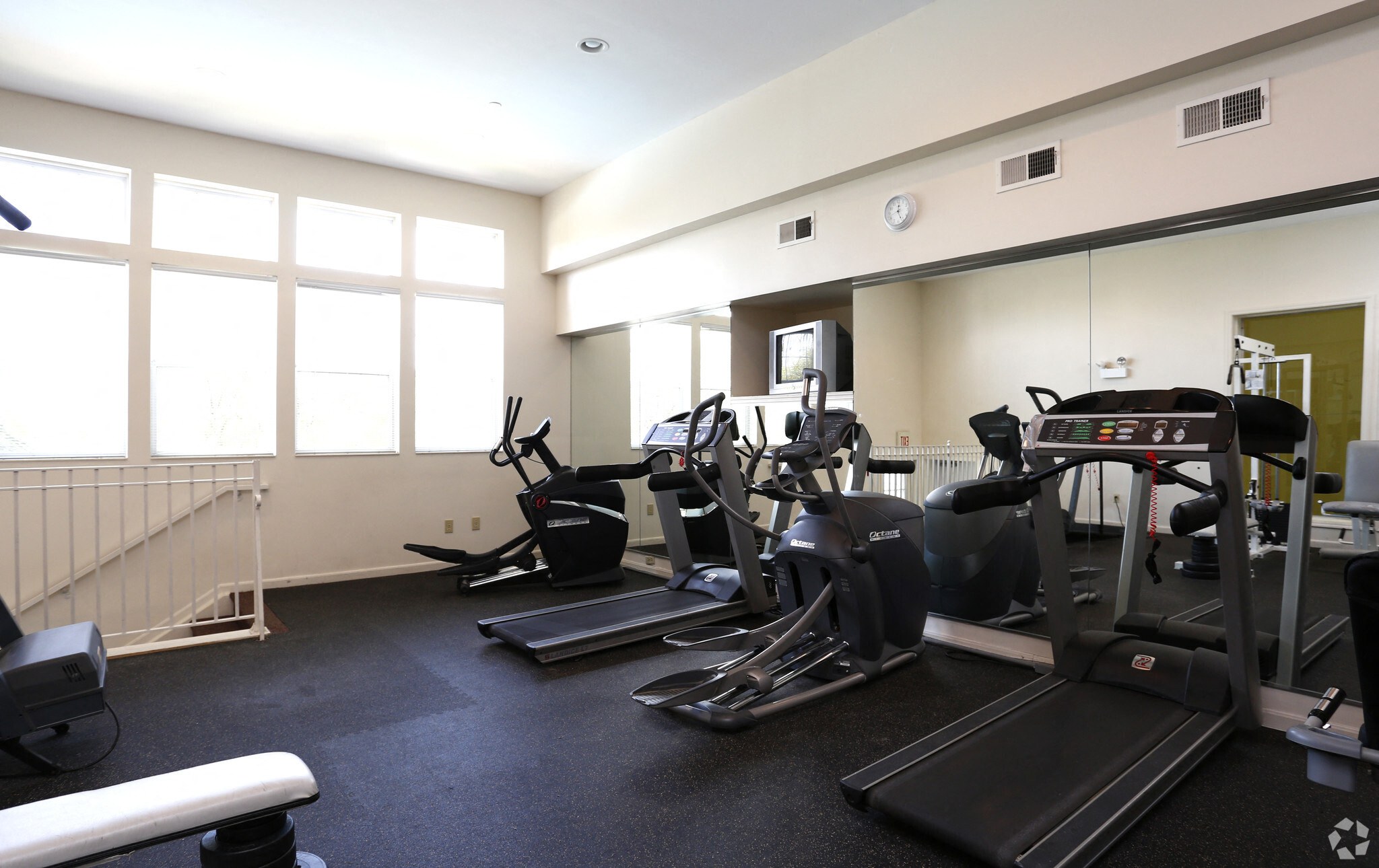 A spacious gym with treadmills, elliptical machines, and other exercise equipment.