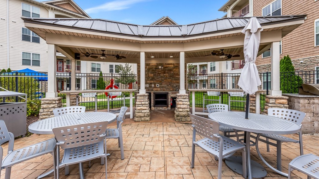 a patio with tables and chairs in front of a building at Vanguard Crossing, Missouri 63124