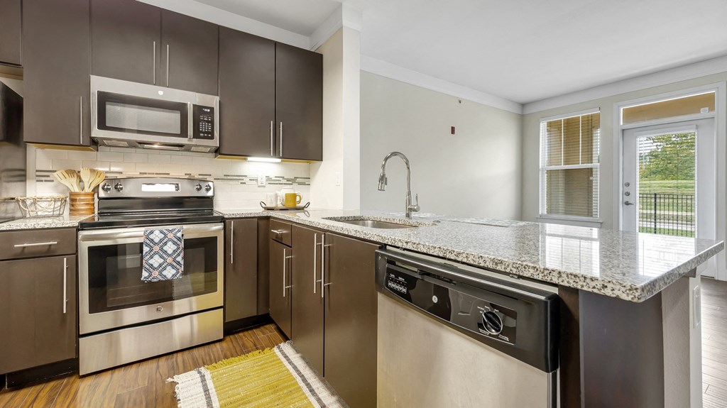 a kitchen with stainless steel appliances and granite counter tops at Vanguard Crossing, Missouri