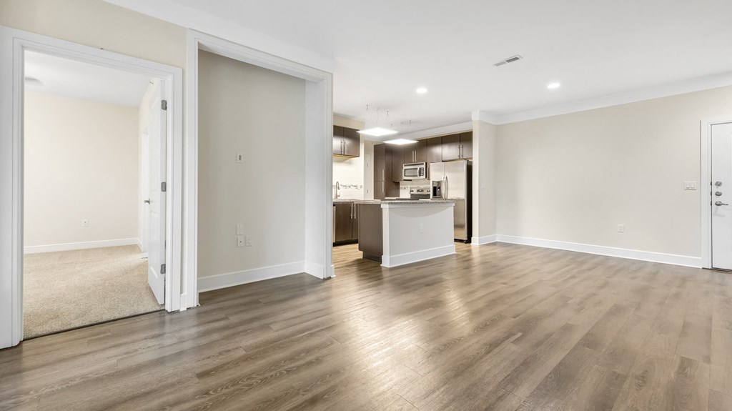 an empty room with white walls and a wood floor at Vanguard Crossing, St. Louis, 63124