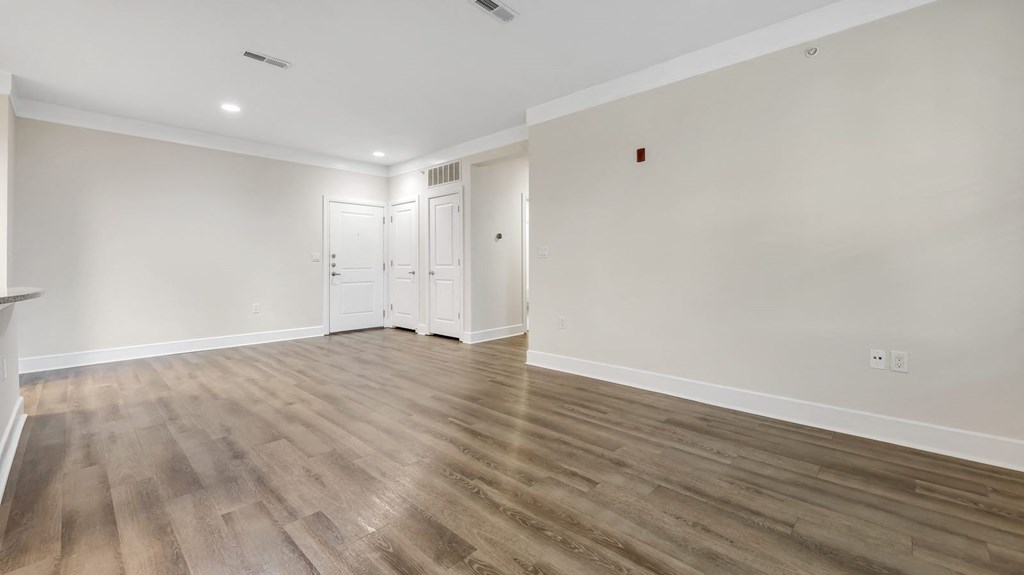 an empty living room with white walls and wood floors at Vanguard Crossing, Missouri 63124