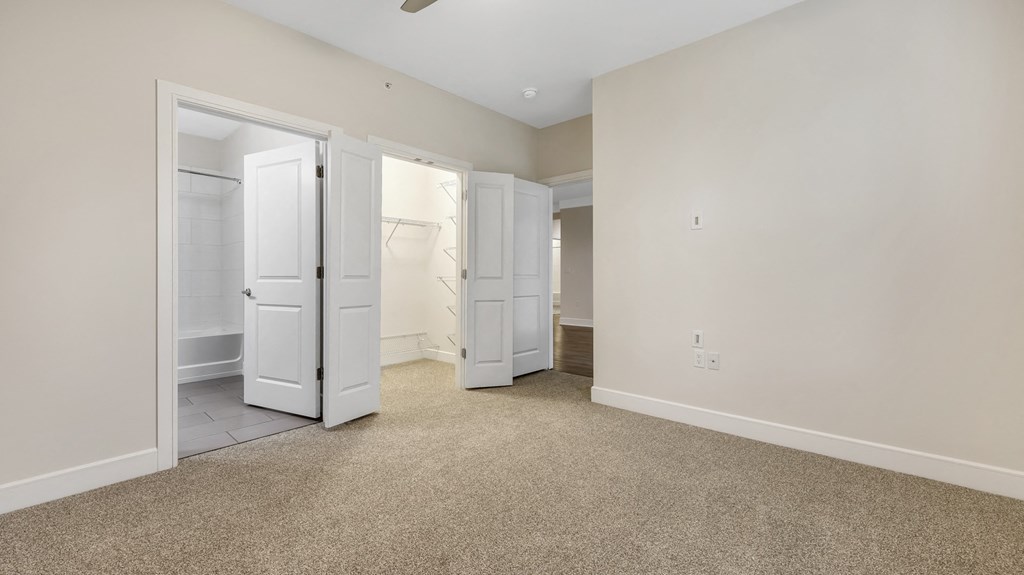 an empty bedroom with two closets and a bathroom at Vanguard Crossing, Missouri