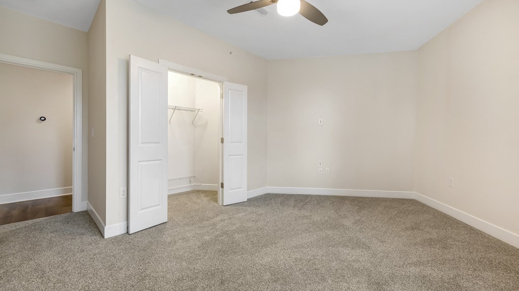 an empty living room with a closet and a ceiling fan at Vanguard Crossing, St. Louis