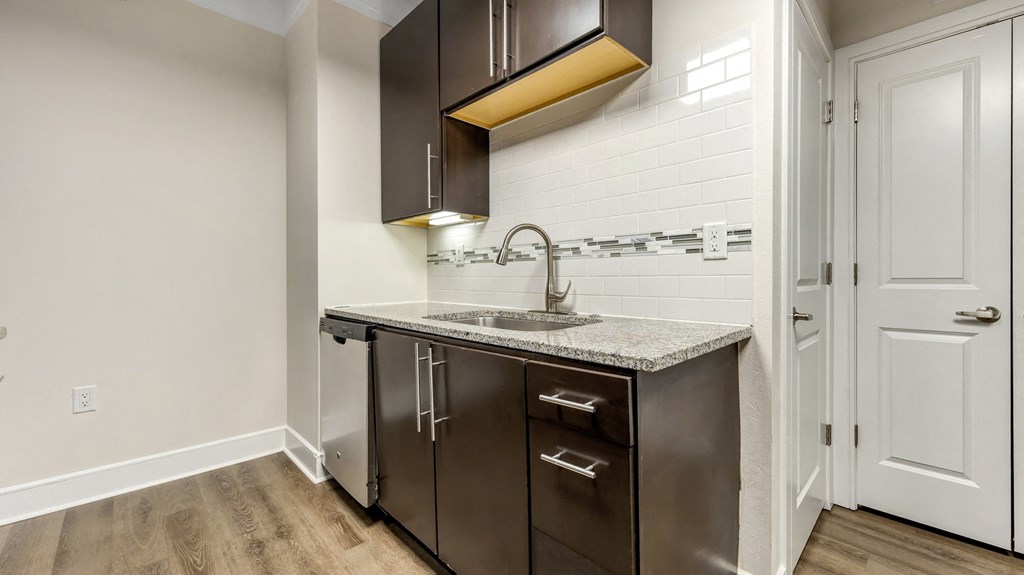 a kitchen with dark cabinets and a sink and a faucet at Vanguard Crossing, St. Louis, 63124