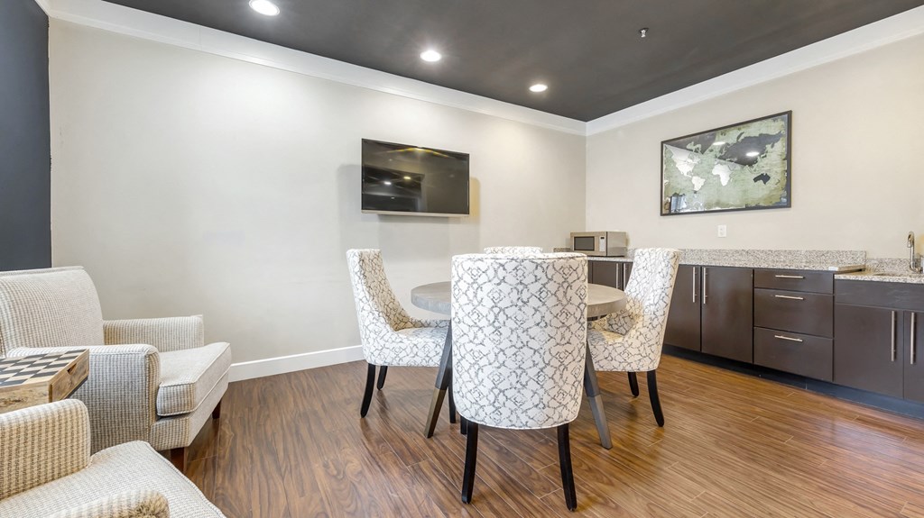 a living room with a dining room table and chairs and a television at Vanguard Crossing, St. Louis, MO