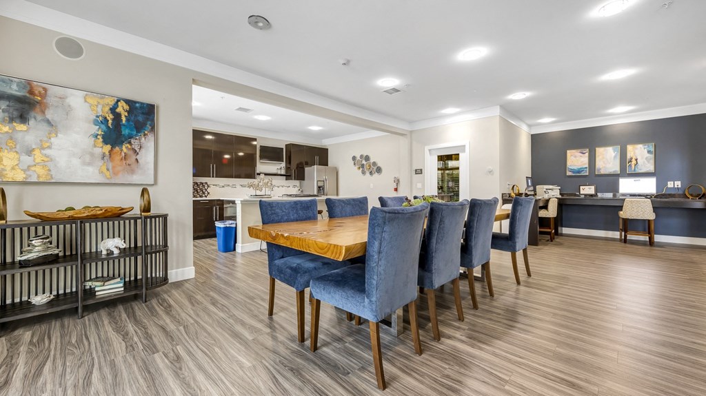 a dining room with blue chairs and a wooden table at Vanguard Crossing, St. Louis, MO 63124