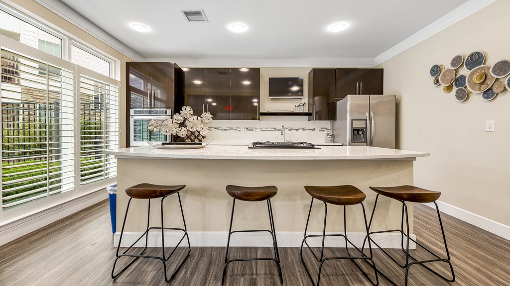 a kitchen with a large island with three stools at Vanguard Crossing, St. Louis, 63124
