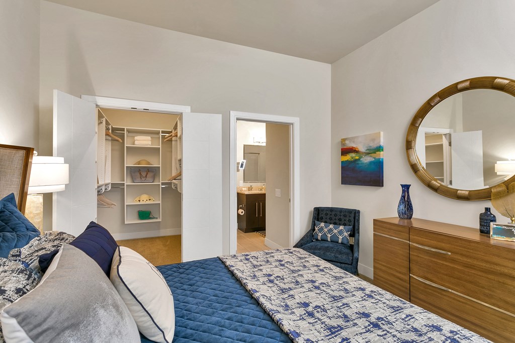 a bedroom with a bed and a mirror and a closet at Aster Apartments, Beachwood, OH