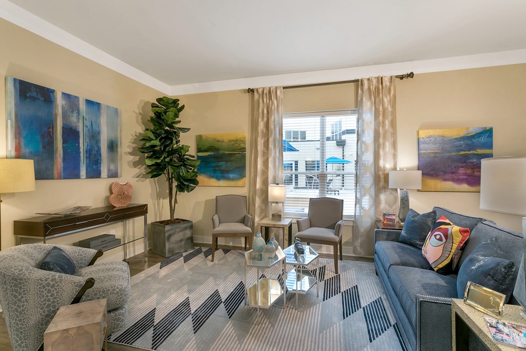a living room with a blue couch and a glass coffee table at Aster Apartments, Beachwood Ohio
