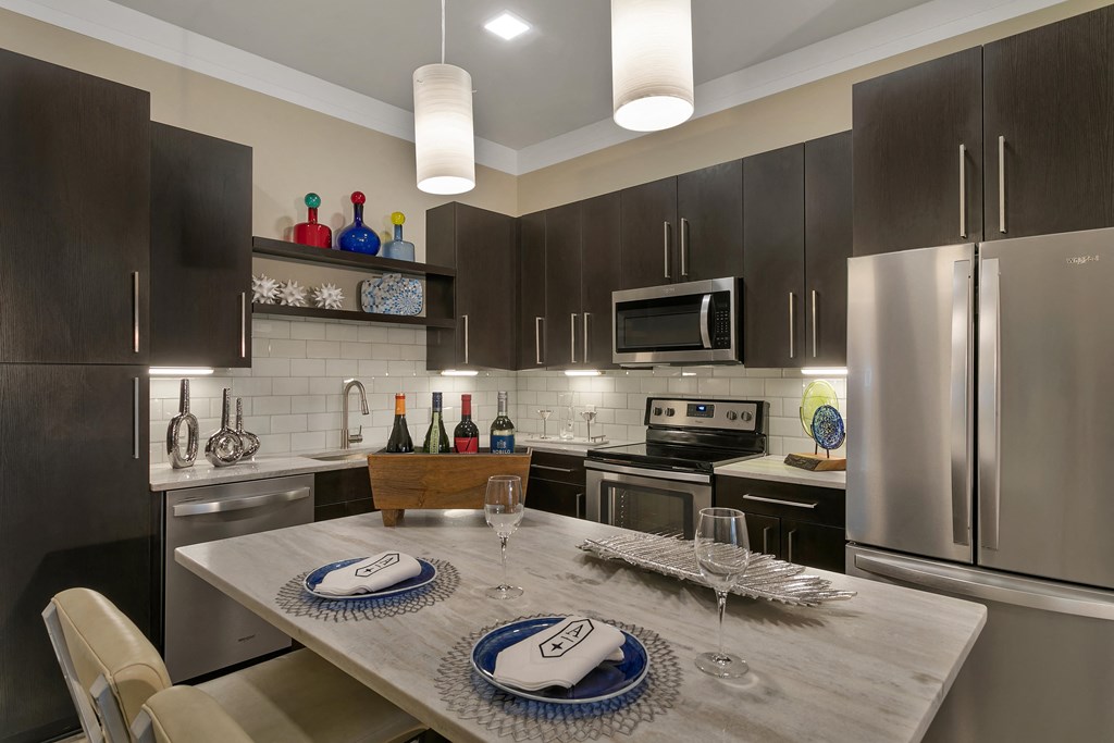 a kitchen with stainless steel appliances and a dining table at Aster Apartments, Ohio, 44122