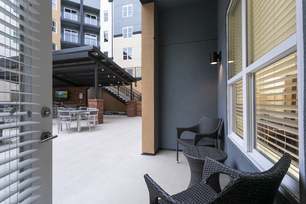 a patio with two chairs and a table in front of a door at Aster Apartments, Beachwood Ohio