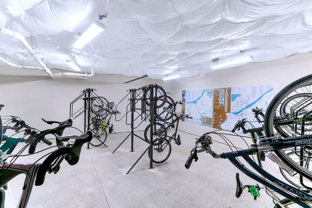 a room filled with bikes and paintings on the wall at Aster Apartments, Ohio, 44122