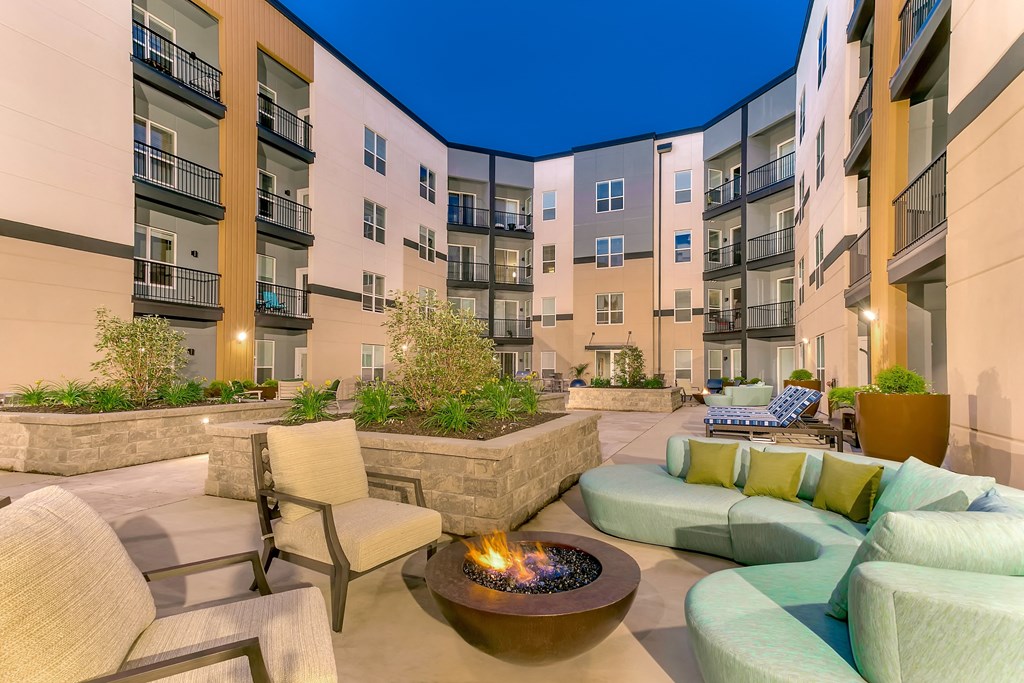 an outdoor patio with couches and chairs and a fire pit at Aster Apartments, Ohio