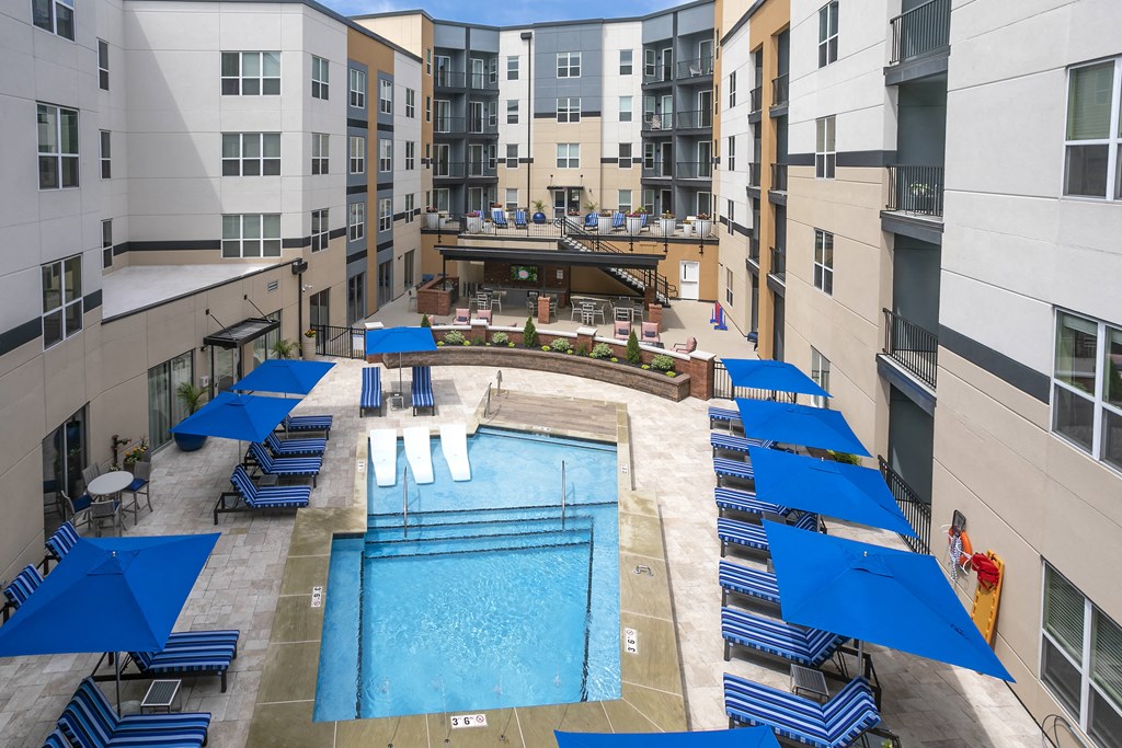 an overhead view of an apartment pool with blue umbrellas at Aster Apartments, Ohio