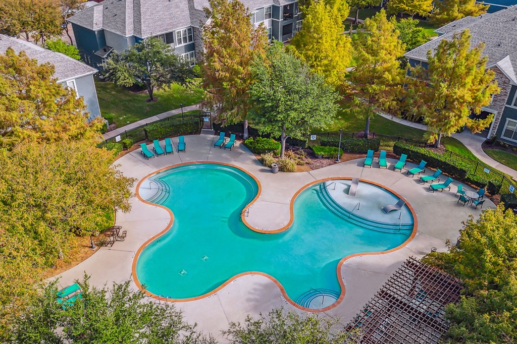 an aerial view of a swimming pool with chairs around it
