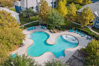 an aerial view of an outdoor swimming pool with lounge chairs around it