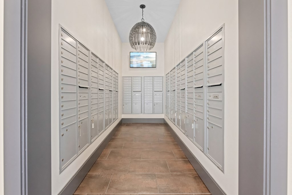 A long hallway with a chandelier and a row of mailboxes on the wall at Aster Apartments, Ohio