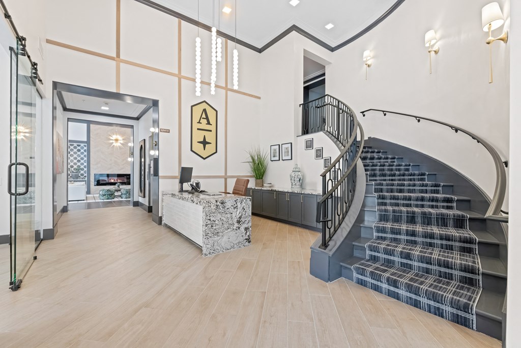 A modern interior with a staircase and a reception desk at Aster Apartments, Beachwood