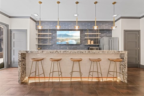 A kitchen with a bar area featuring a granite counter and bar stools.