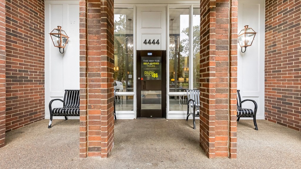 the entrance to a building with two benches in front of a door