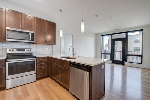 A modern kitchen with wooden cabinets and stainless steel appliances.