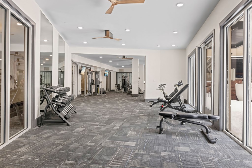 A gym with a grey carpet and a fan on the ceiling at Aster Apartments, Beachwood, OH 44122