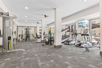 A gym with a variety of exercise equipment and a treadmill at Aster Apartments, Beachwood, OH