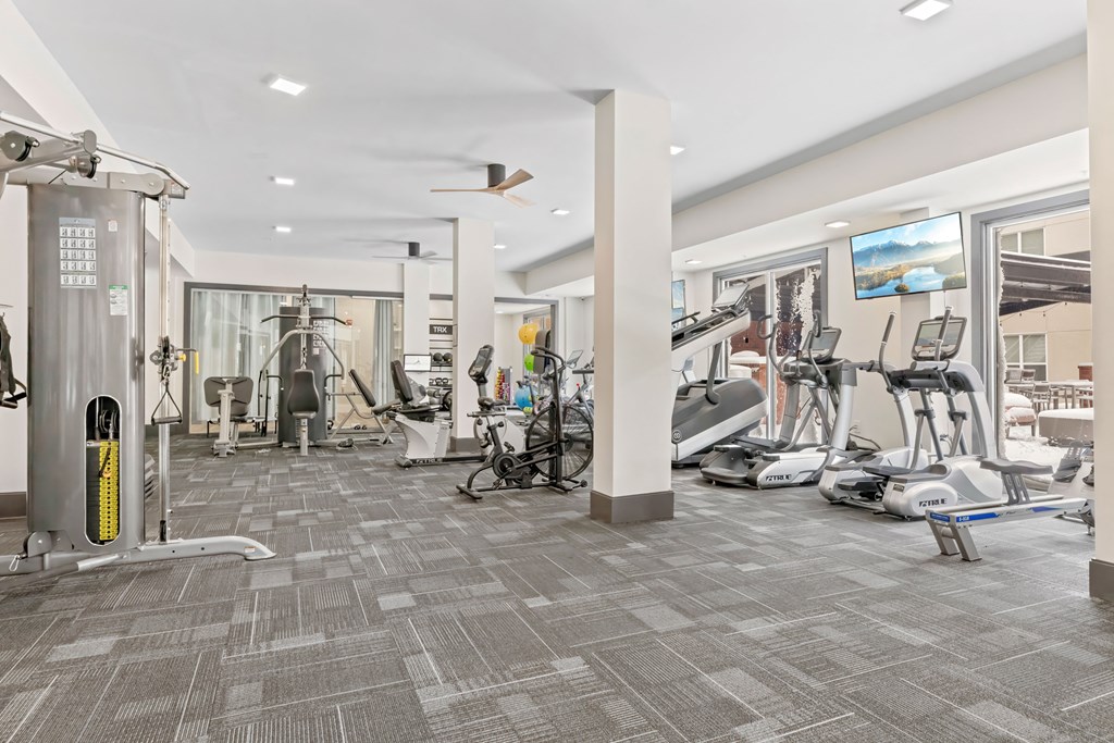 A gym with a variety of exercise equipment and a treadmill at Aster Apartments, Ohio, 44122