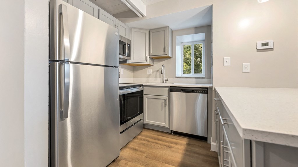 a kitchen with stainless steel appliances and white cabinets
