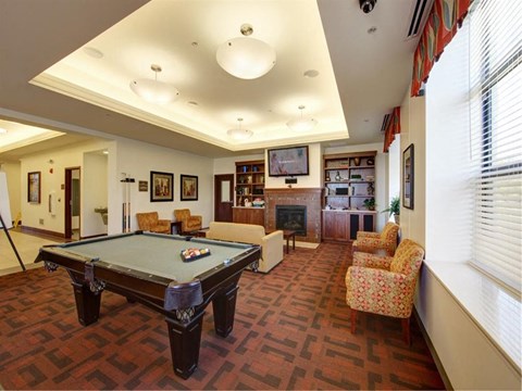 a game room with a pool table and chairs