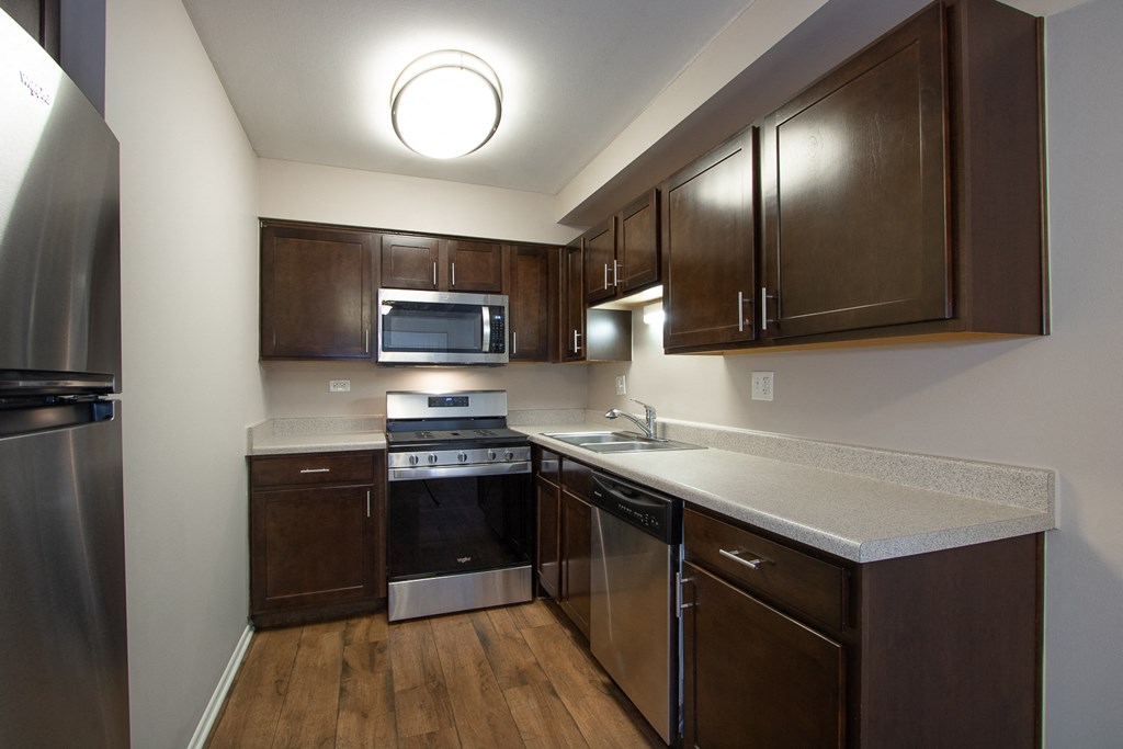 Espresso Cabinets with Stainless Steel Appliances in Kitchens at The Greenway at Carol Stream, Carol Stream, Illinois 60188