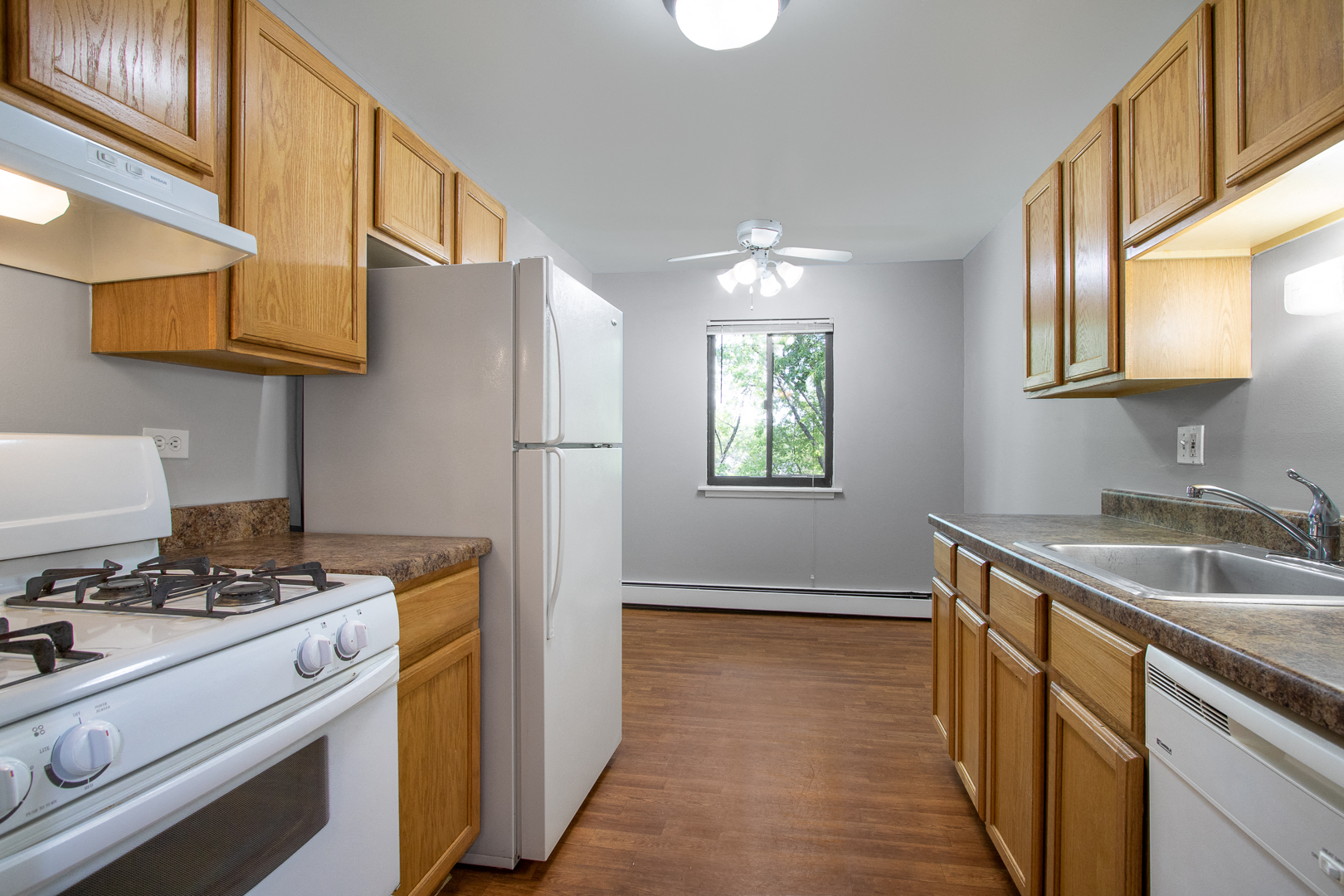 a kitchen with white appliances and wooden cabinets