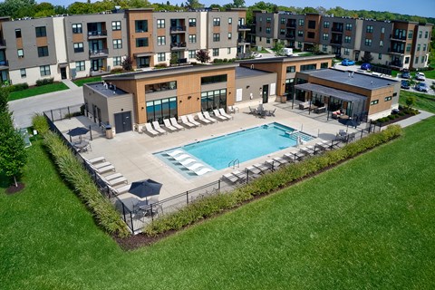 an aerial view of a pool with chairs and a building at Statesman Apartments, Franklin, 53132