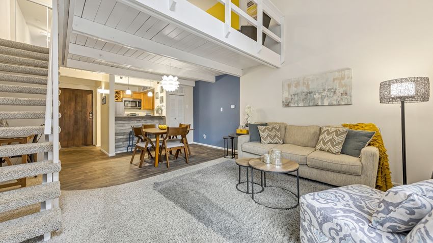 a living room with a couch and a table and a kitchen