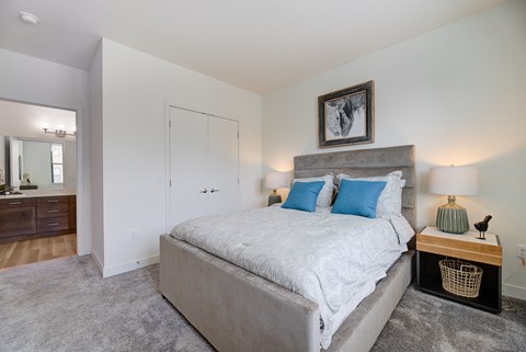 a bedroom with a large bed and a closet at Statesman Apartments, Wisconsin 53132