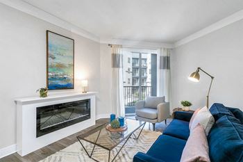 a living room with a blue couch and a fireplace at Aster Apartments, Beachwood, 44122