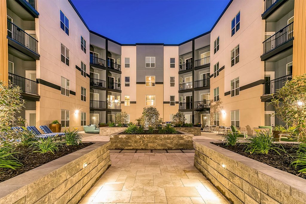 a courtyard with a stone wall in the middle of an apartment building at Aster Apartments, Beachwood, OH 44122