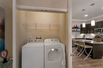 a washer and dryer in a laundry room next to a kitchen at Aster Apartments, Ohio