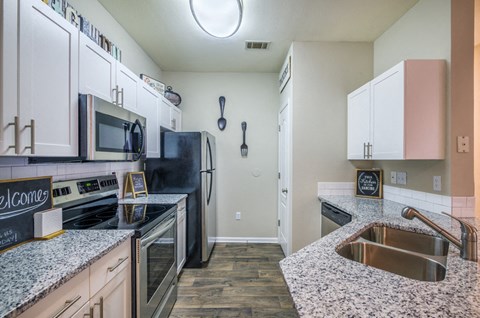 a kitchen with granite counter tops and stainless steel appliances