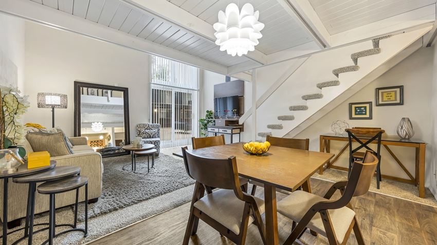 a living room with a dining room table and a staircase